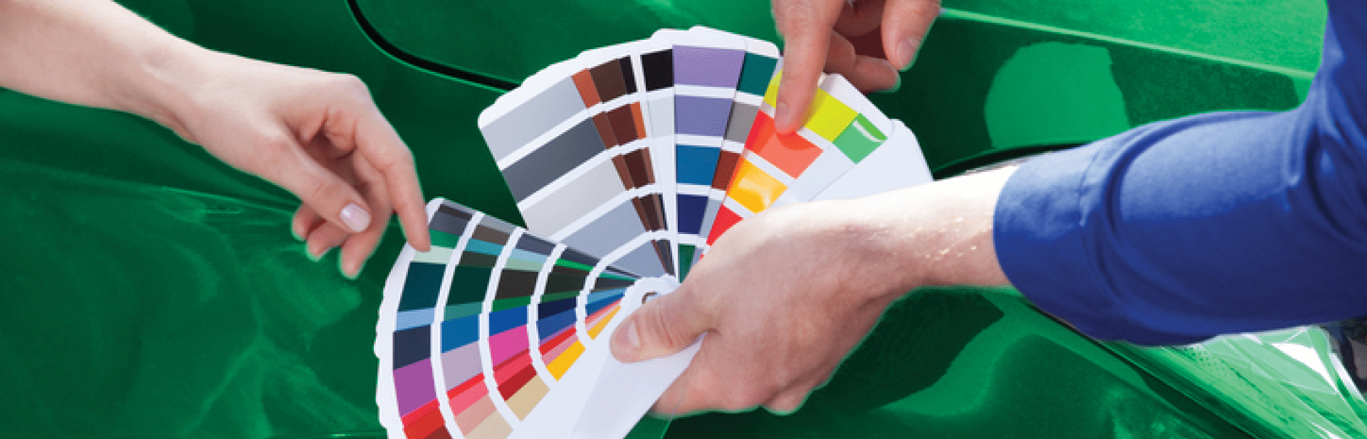 Cropped image of mechanic showing color samples to customer against car