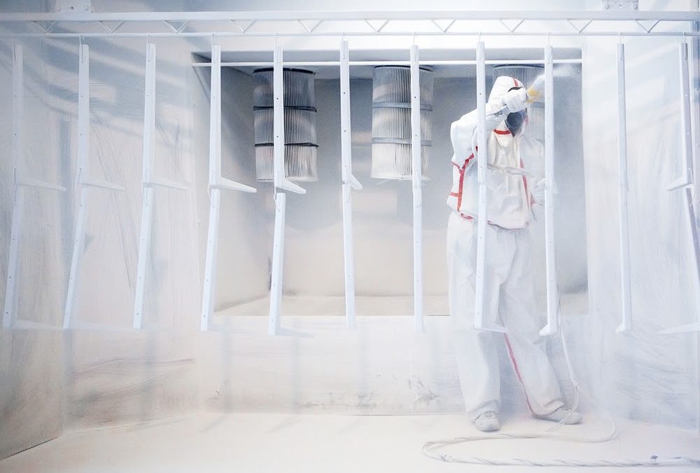 Worker wearing protective wear using a Powder Booth